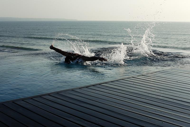 Alila Seminyak Hotel Exterior foto A swimmer entering the sea at the beach of the resort